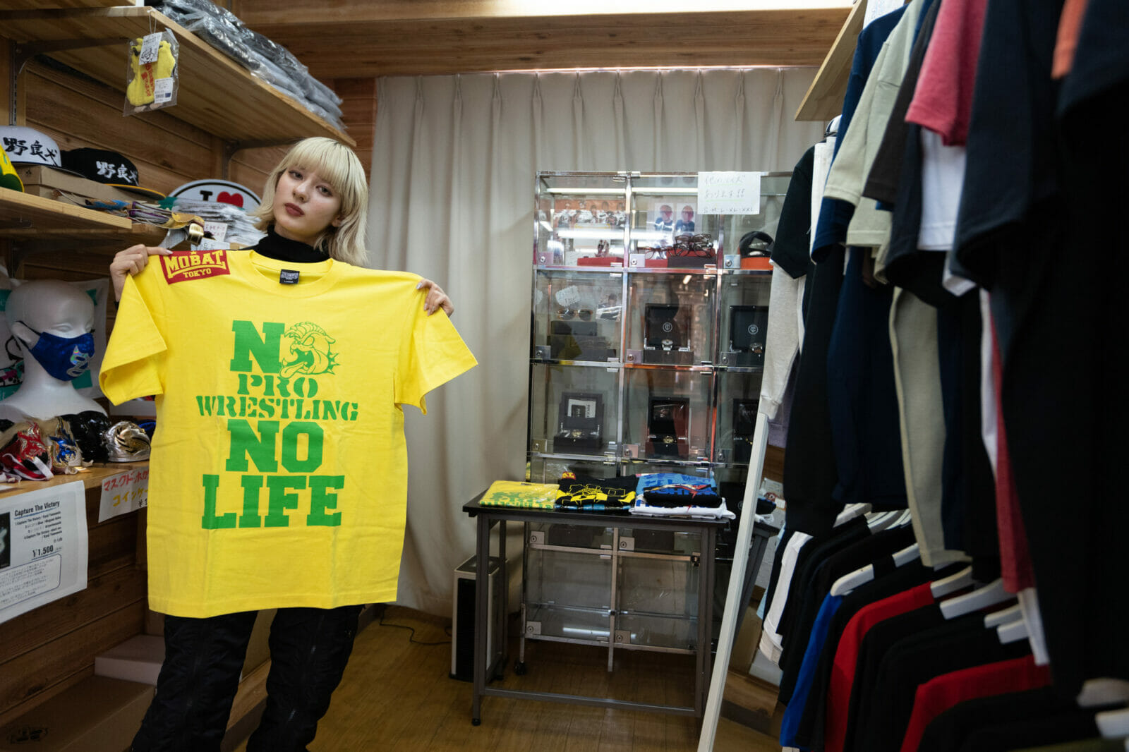 “NO PROWRESTLING NO LIFE”と描かれたTシャツを持つ友沢さん。